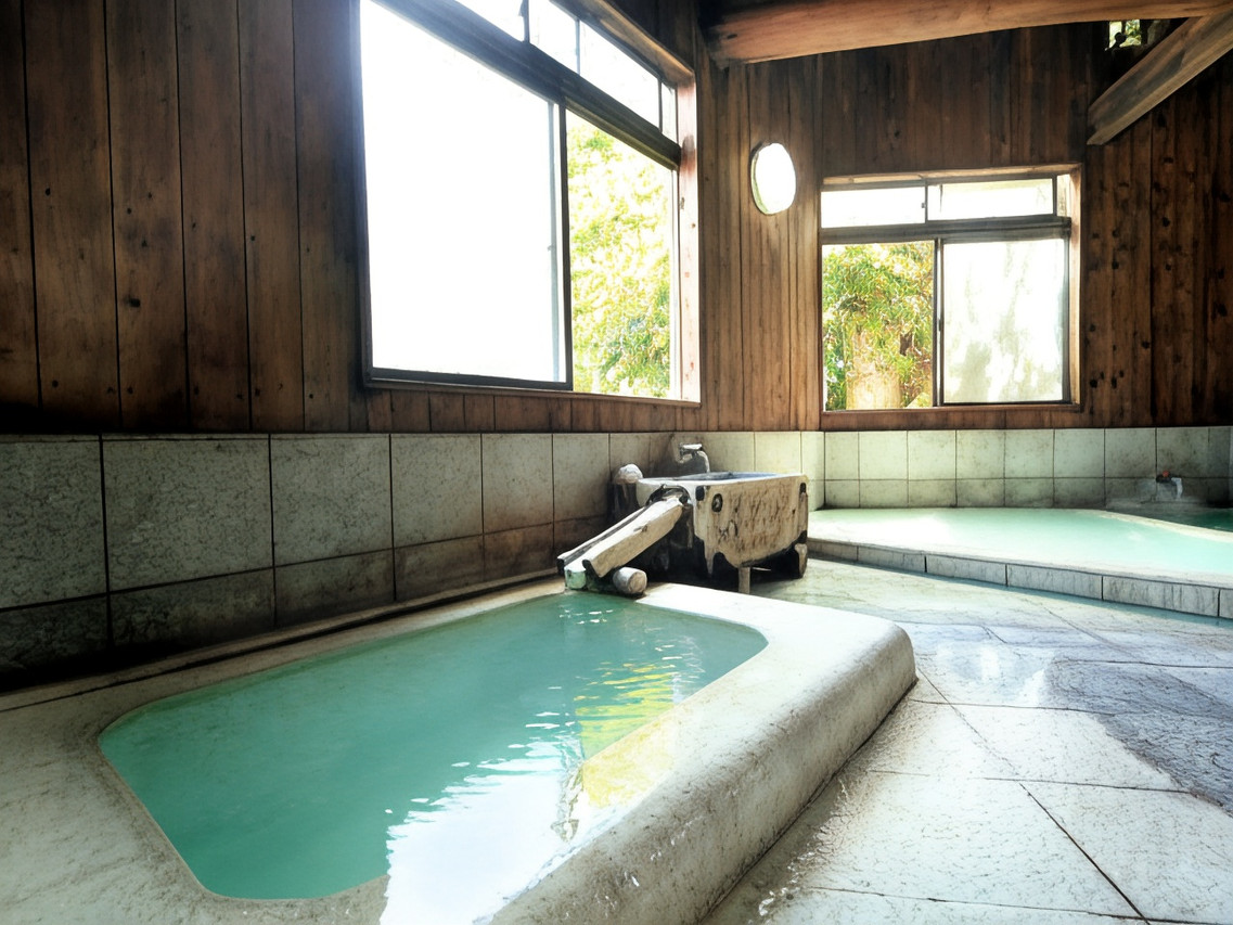 A spacious indoor bath has multiple tiled pools and timber walls.