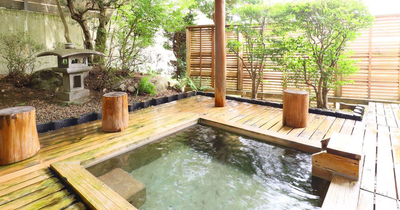 Hayataro Onsen Nagomi no Yuyado Nakayama with an outdoor timber bath surrounded by leafy garden walls.