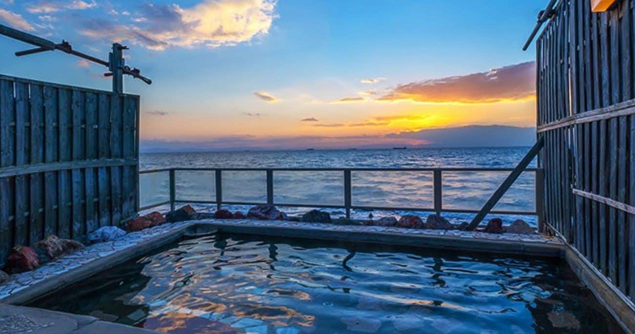 Kaien Onsen Yumoto Hotel Onoura with an open-air bath facing a vivid coastal sunset.