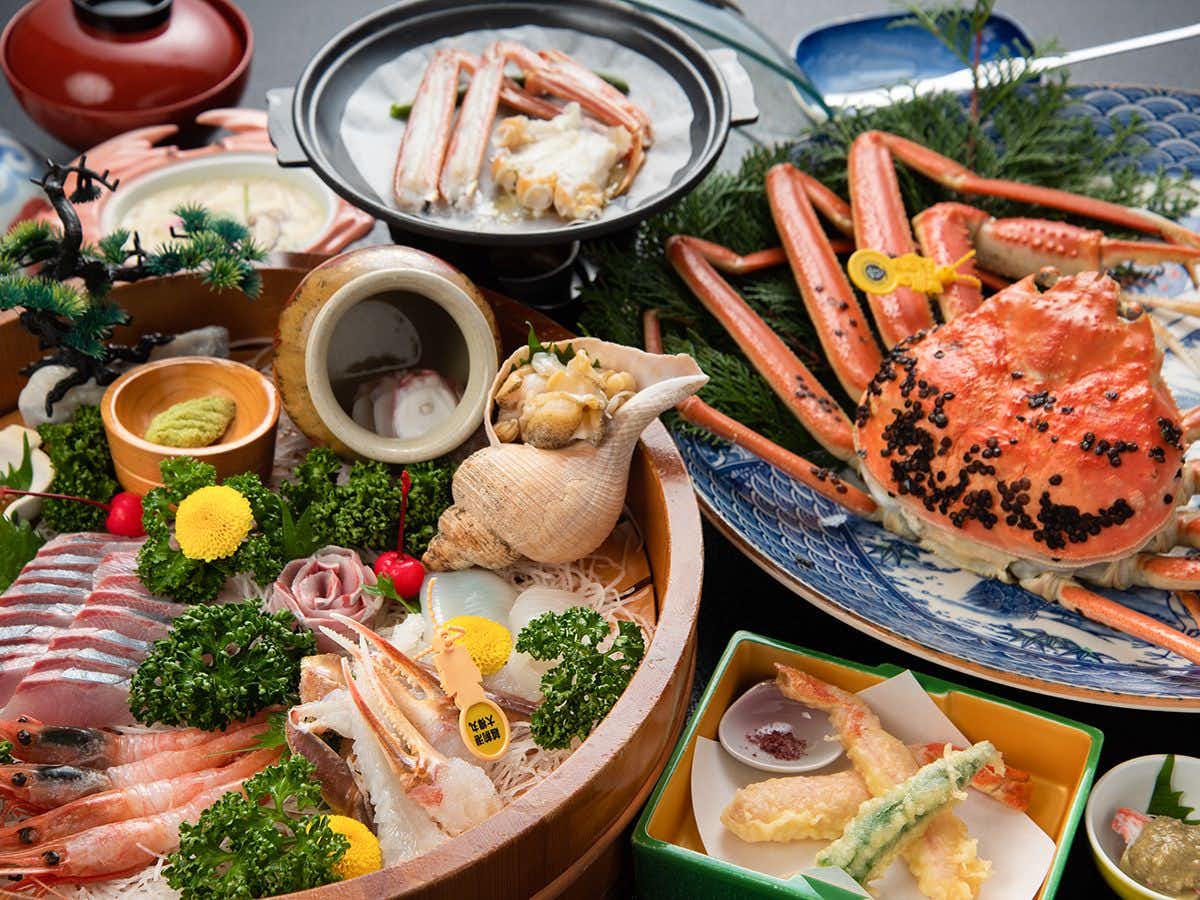 Kuriya Onsen Imai Ryokan with this scene, where snow crab, sashimi and shellfish fill a brightly arranged seafood spread.
