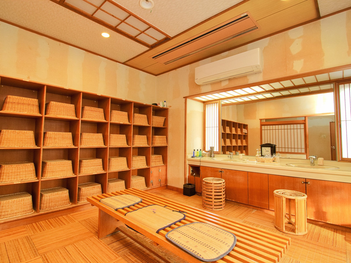 A timber bathing area is arranged with shelves and wash stools.