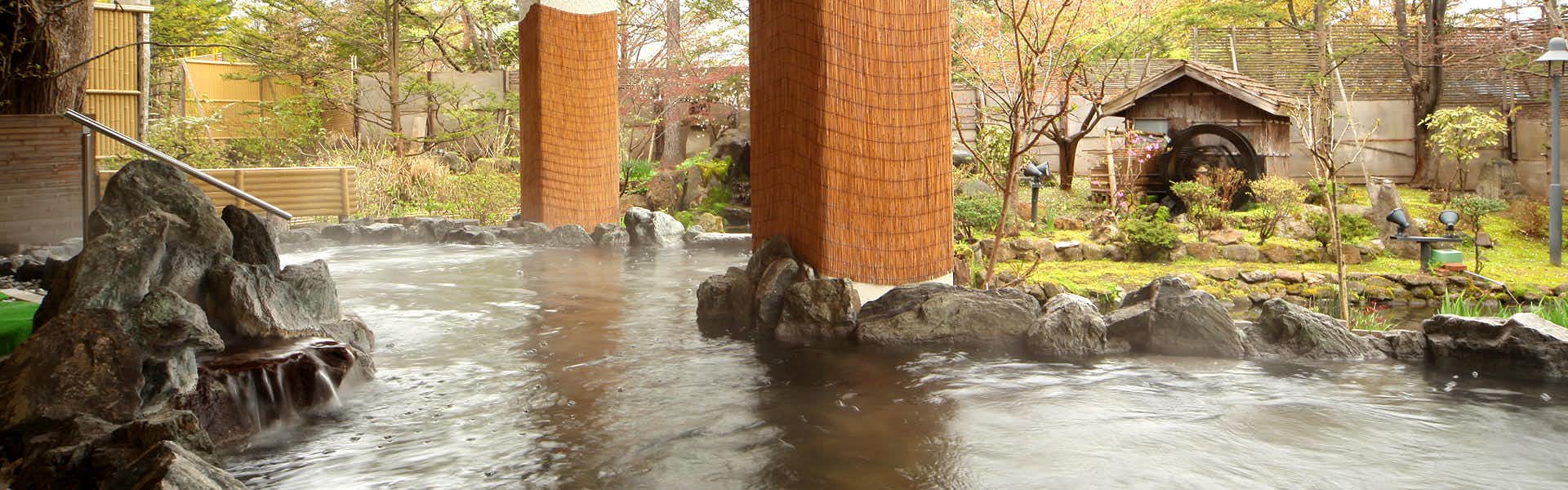 Otaru Kourakuen with an open-air stone bath overlooking an autumn garden.