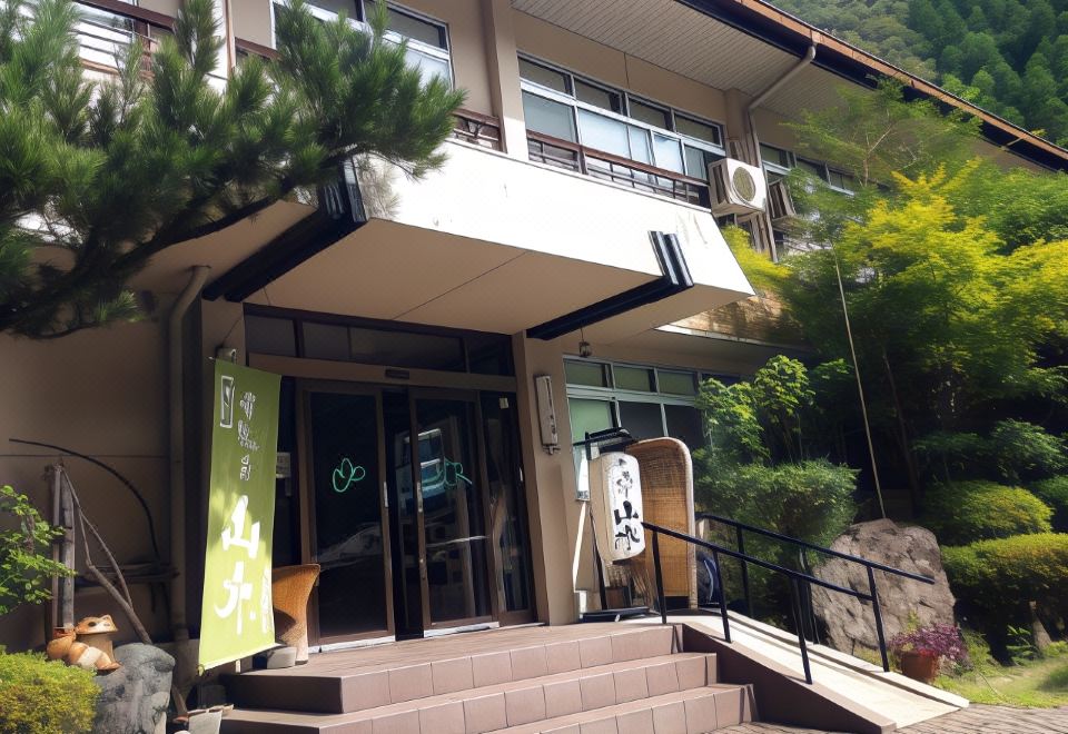 Steps and a ramp lead to the lodging entrance beneath an upper balcony.