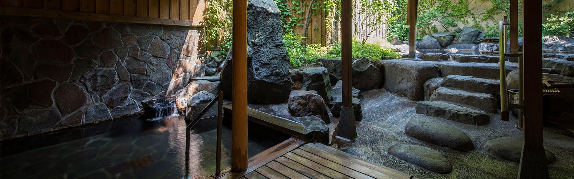 Shousenkaku Kagetsu rock-lined outdoor bath beside stone steps and greenery