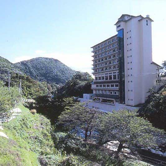 Sanbo Tsukinose with the multistory hotel rising above trees and steep mountains.