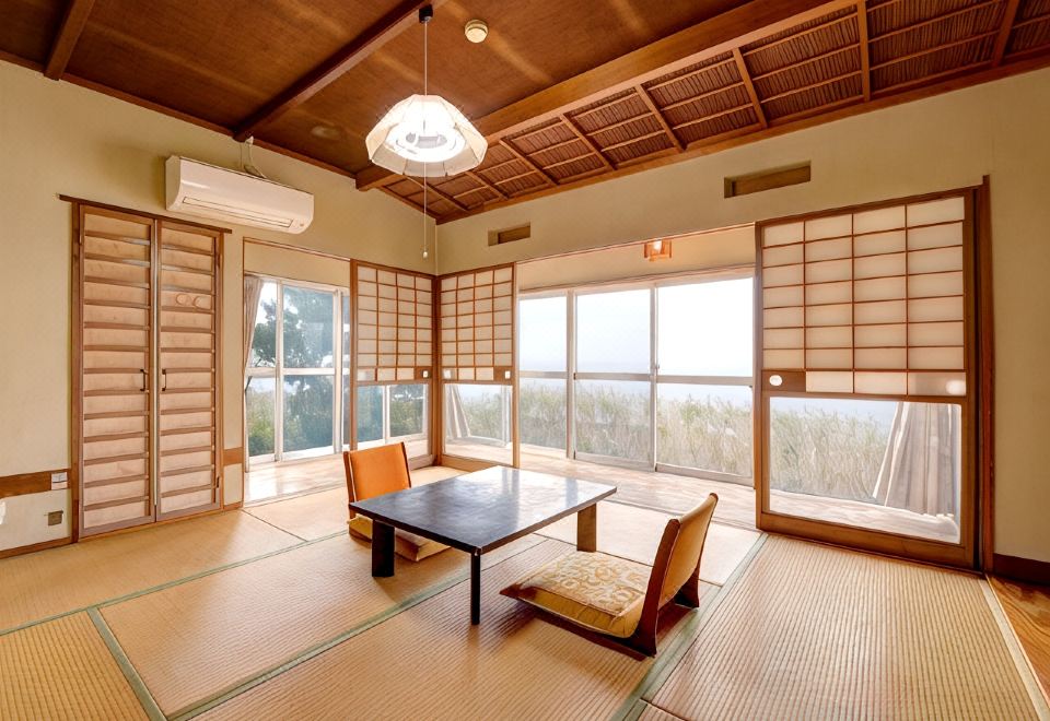 A traditional room with tatami flooring and a view outside.