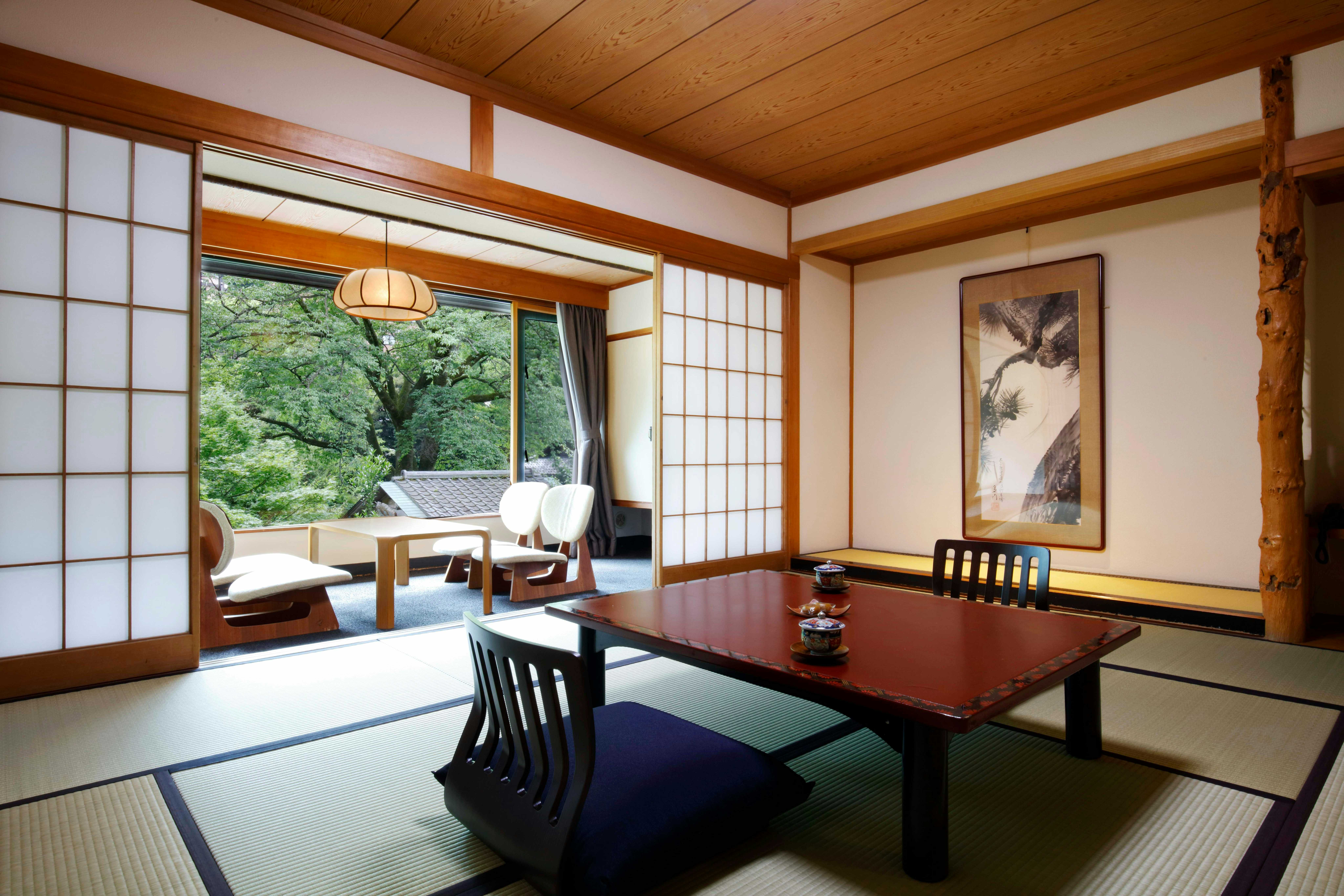Yoshiike Ryokan with a spacious tatami room overlooking dense garden greenery.
