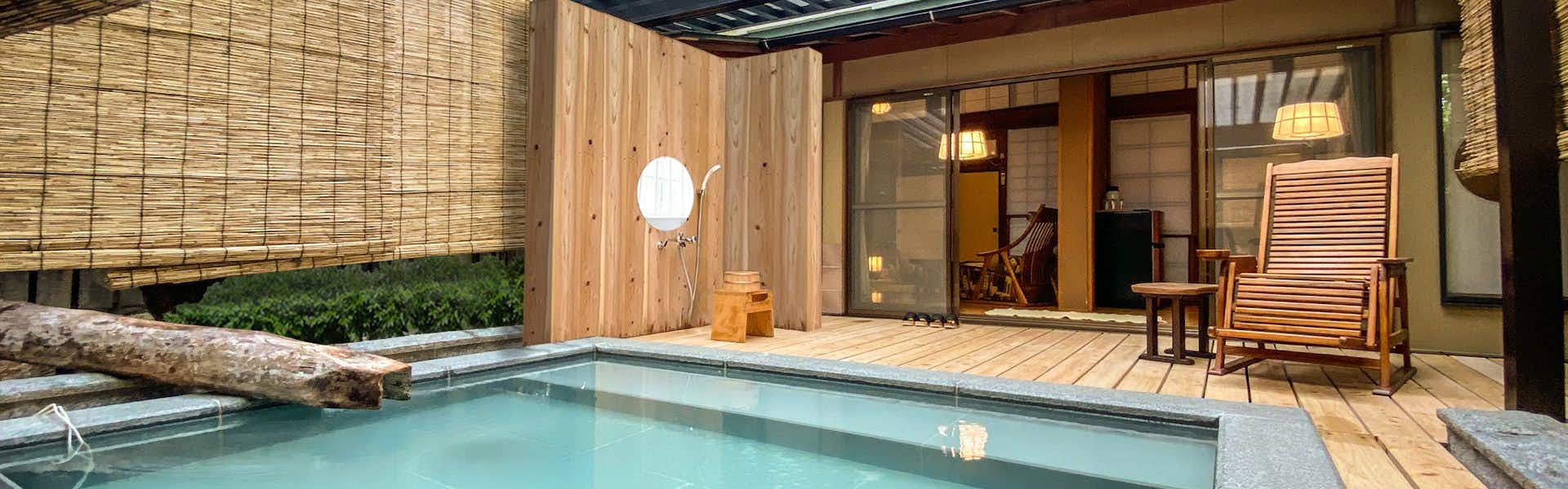Oyado Hanakanzashi rectangular outdoor bath beside a wood deck and chairs