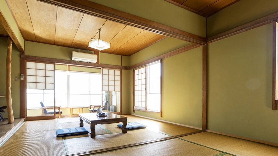 A spacious tatami guest room with a low table and an ocean-facing sitting area.