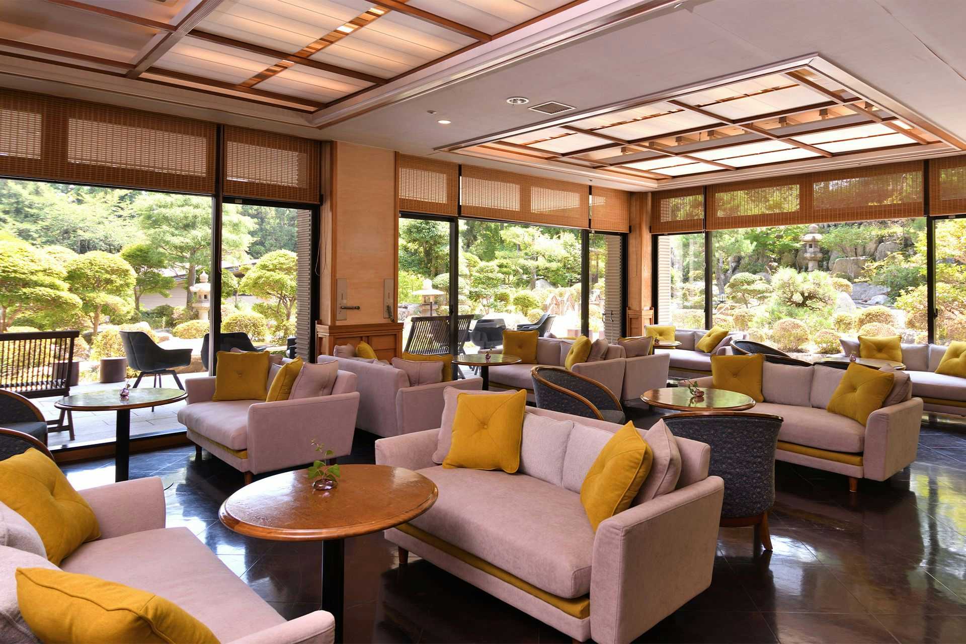 Yunogo Onsen Yunogo Bishunkan with a bright lounge with pale sofas overlooking the garden.