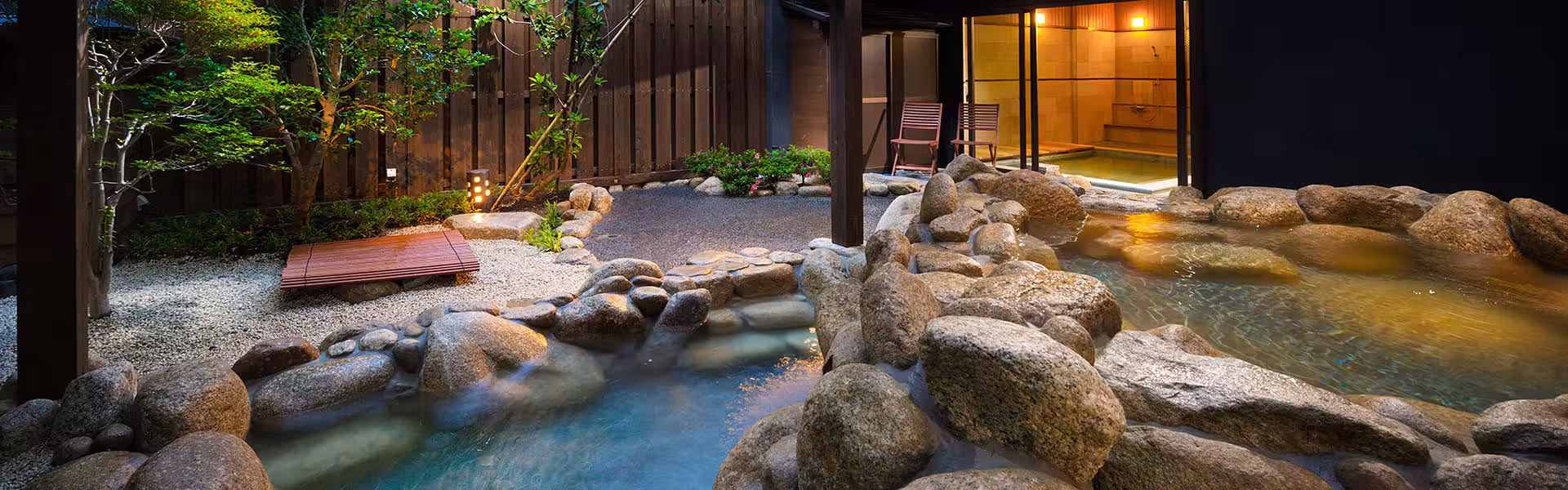 Hirugaminosumika Kurotake with this scene, where a rock-lined open-air bath winds through a sheltered garden.