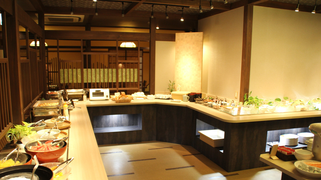 Buffet counter with dishes under warm lighting.