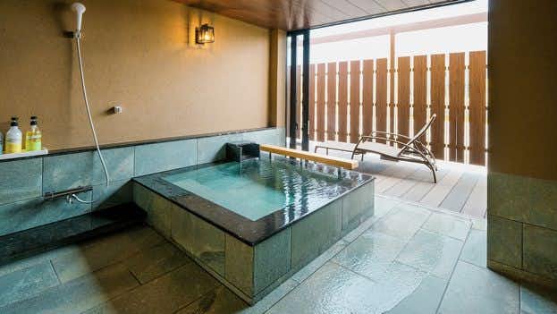 Awara Onsen Hasegawa with a private tiled bath with broad windows and timber privacy screens.