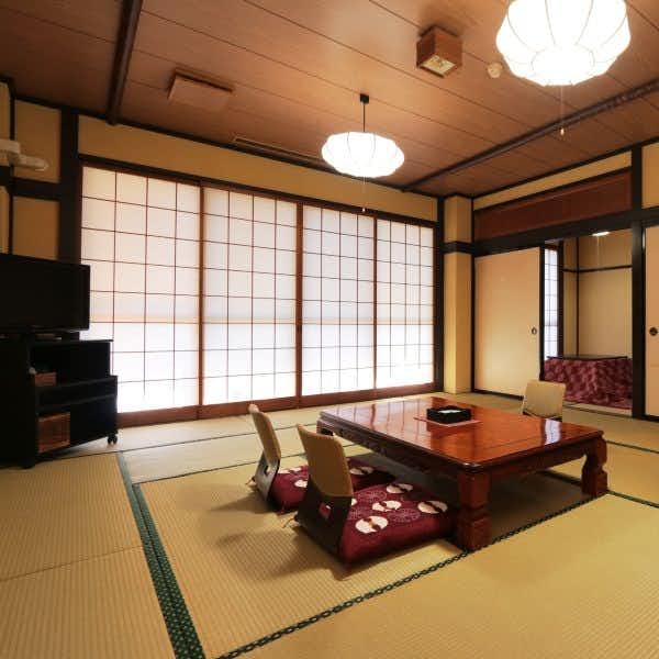Aromatic Flower Hospitality - Susaki Ryokan with a tatami room with red low table and shoji screens.