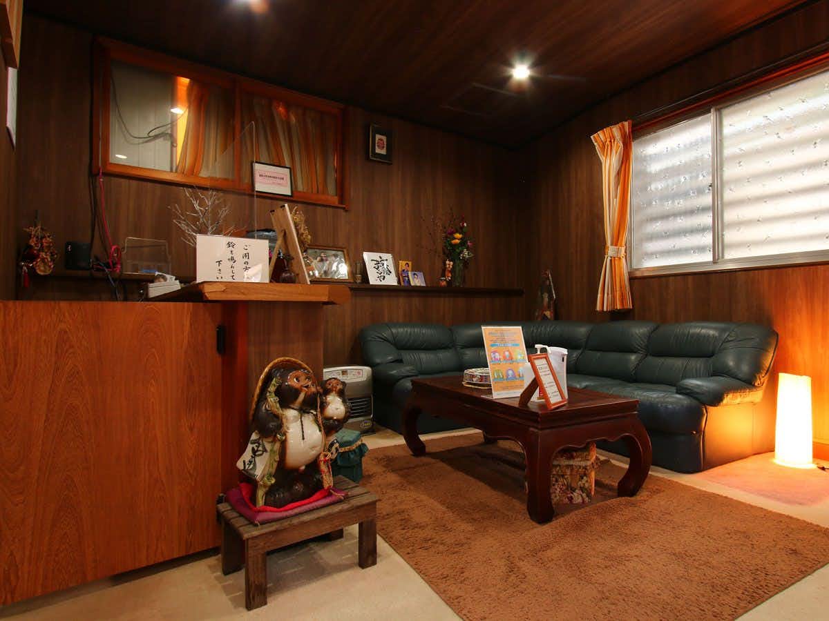 Ryokan Maruya with a welcoming timber lobby with low seating and hanging lanterns.
