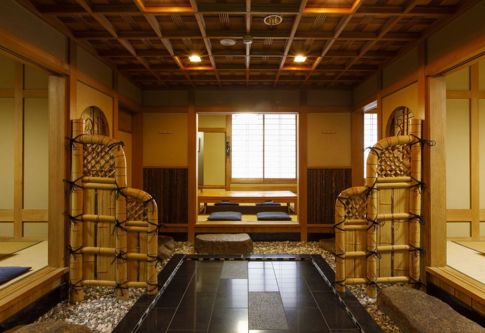 An entrance atrium with polished stone flooring, bamboo-wrapped columns, and a window-side seating alcove.