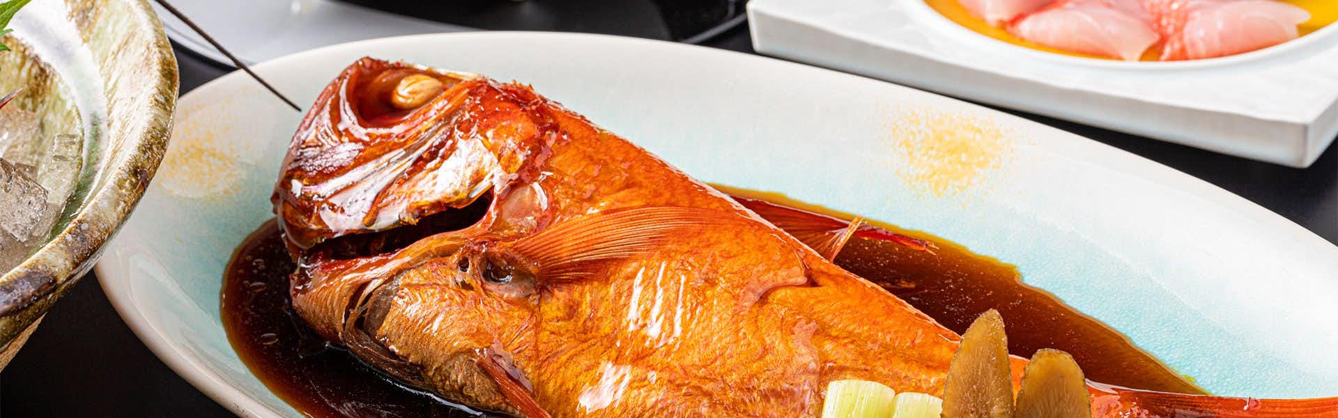 Inatoriso with this scene, where its whole red fish rests in glossy sauce beside pale vegetables.