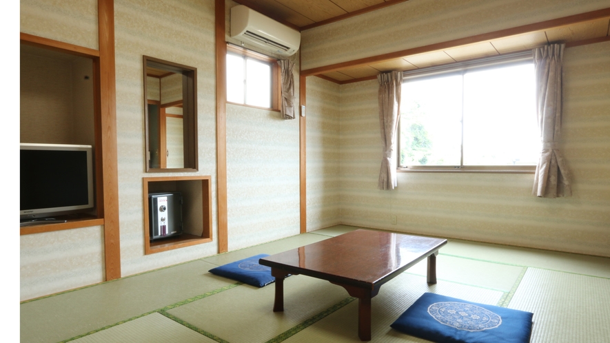 A tatami guest room with a low table, blue floor cushions, and a broad window.