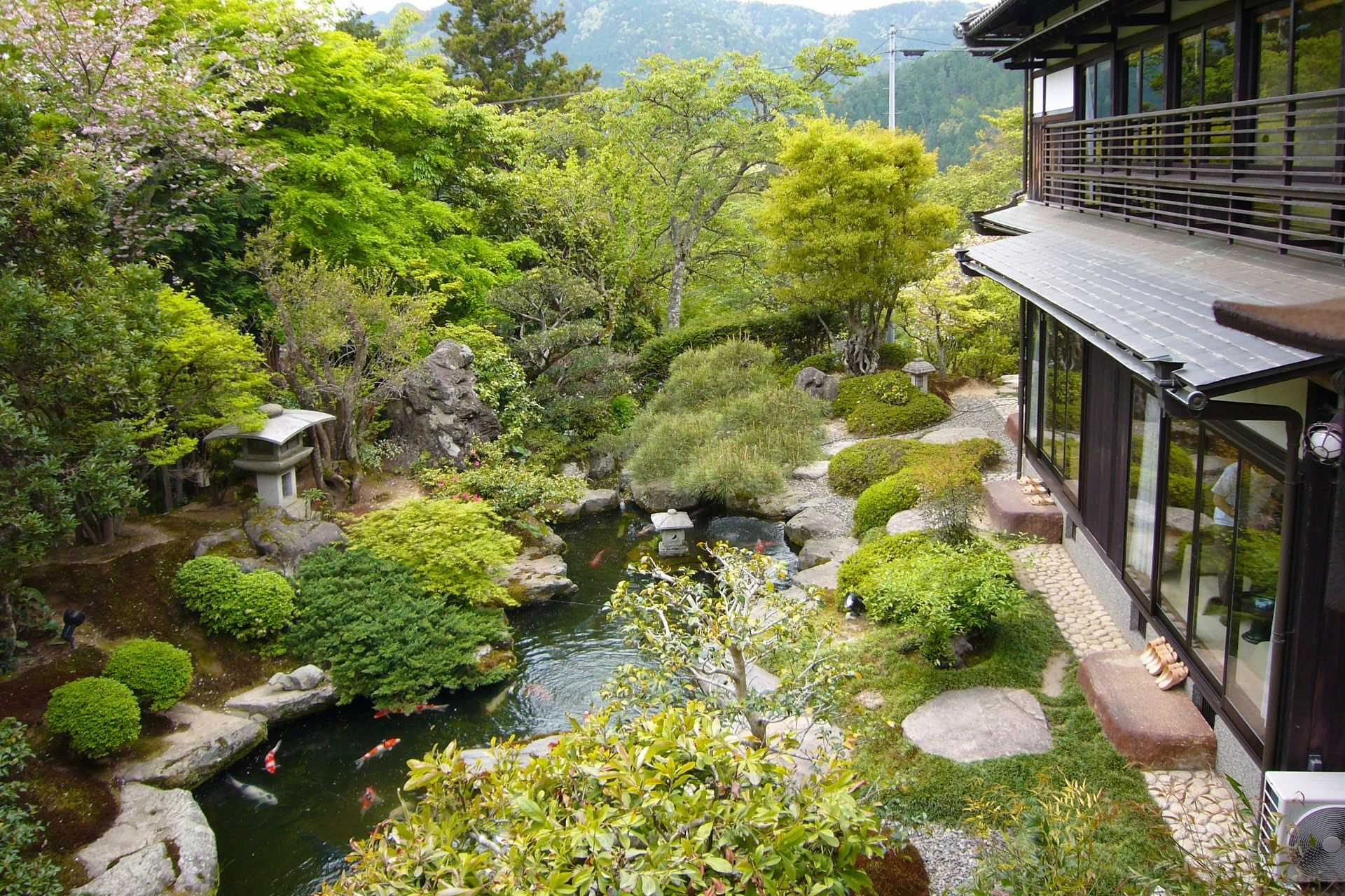 Ohara Onsen Yumoto Shunmi Sosai Oyado Seriyu with a landscaped garden pond surrounded by clipped shrubs.