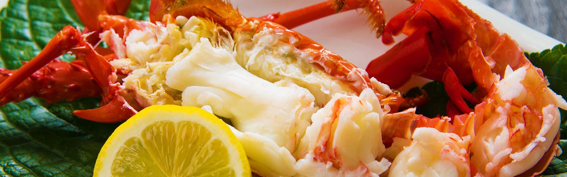 Iseebi Inn with cooked spiny lobster served with lemon on a white plate.