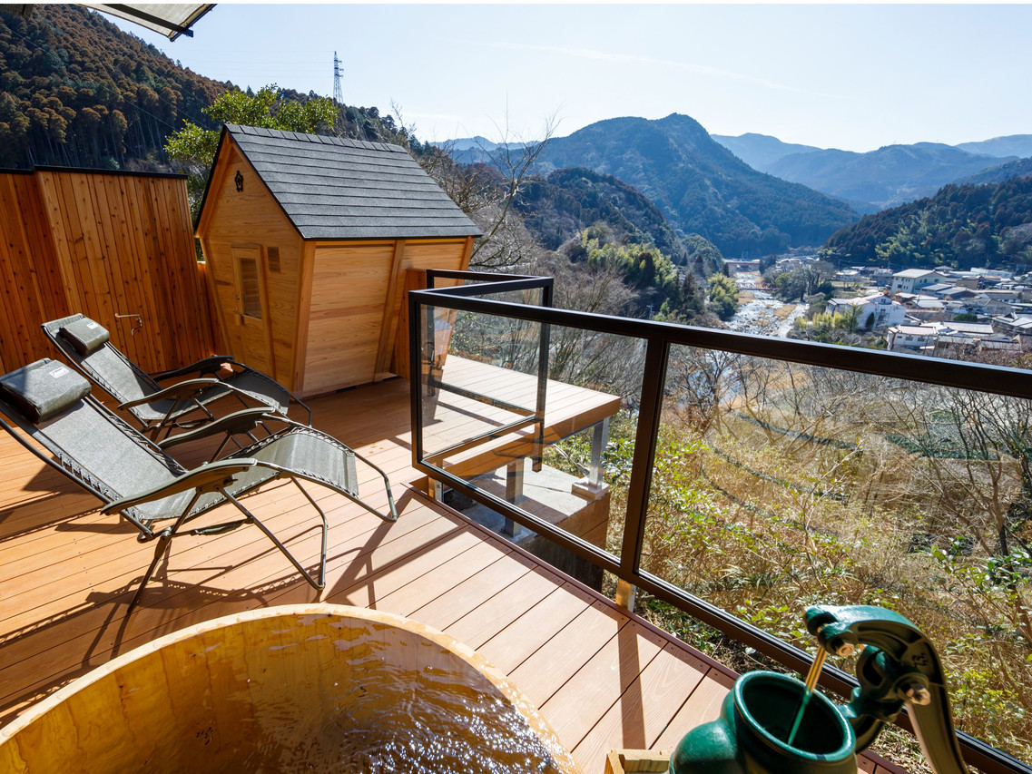 A timber deck carries loungers above the valley.