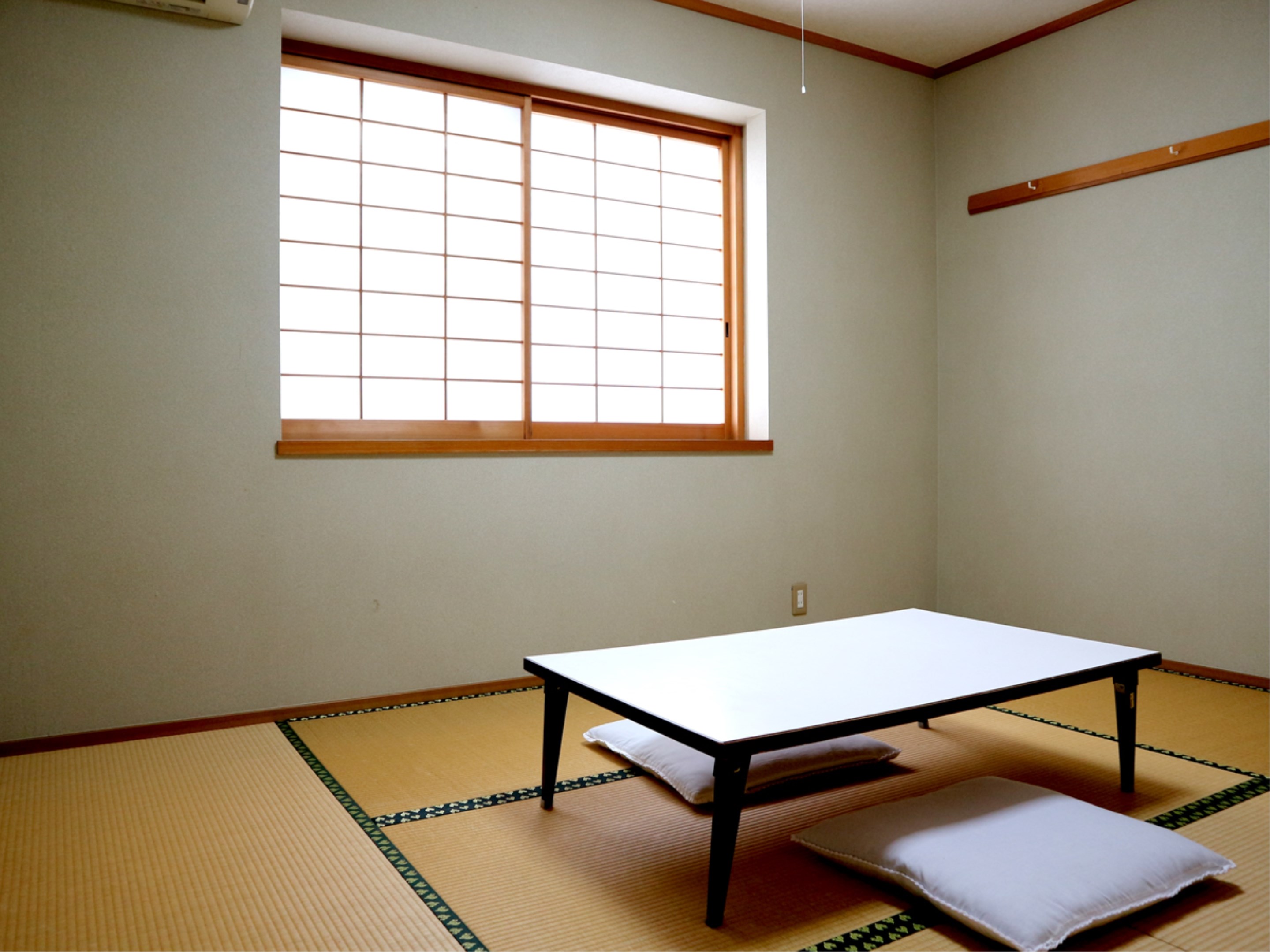 A simple tatami room with a low table and shoji window.
