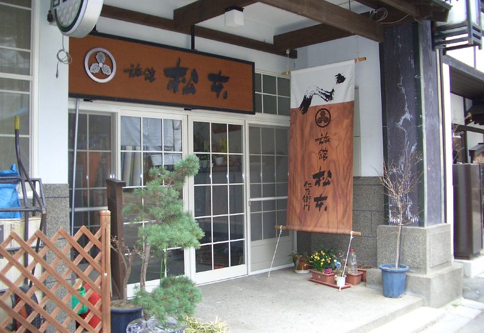 The ryokan entrance with wooden Japanese signs.