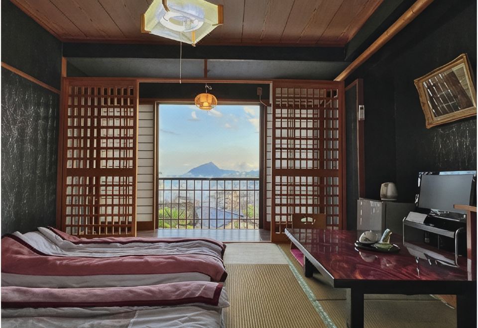 A tatami room with futon bedding and a mountain-facing balcony.