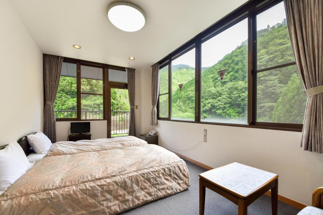 A bedroom with mountain views through wide windows.