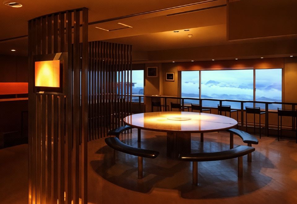 A hotel dining room with a round table and mountain view.