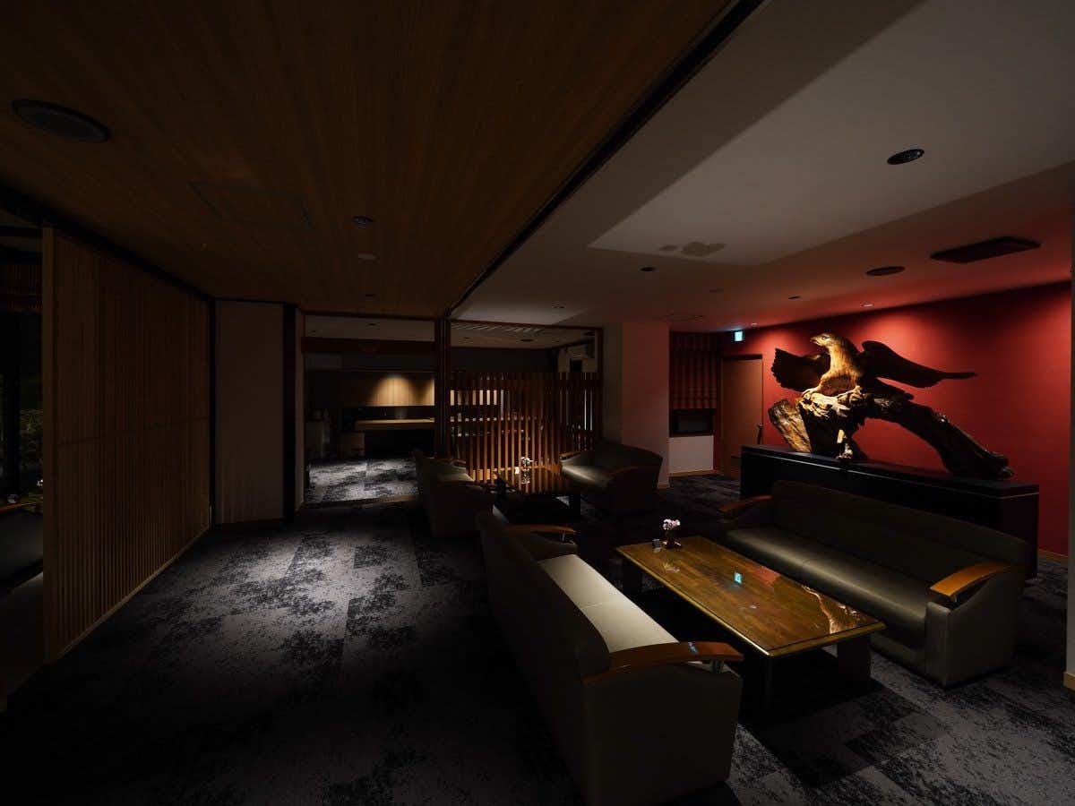 Hotel Kikyou dark lobby seating arranged around a bird sculpture against a red wall