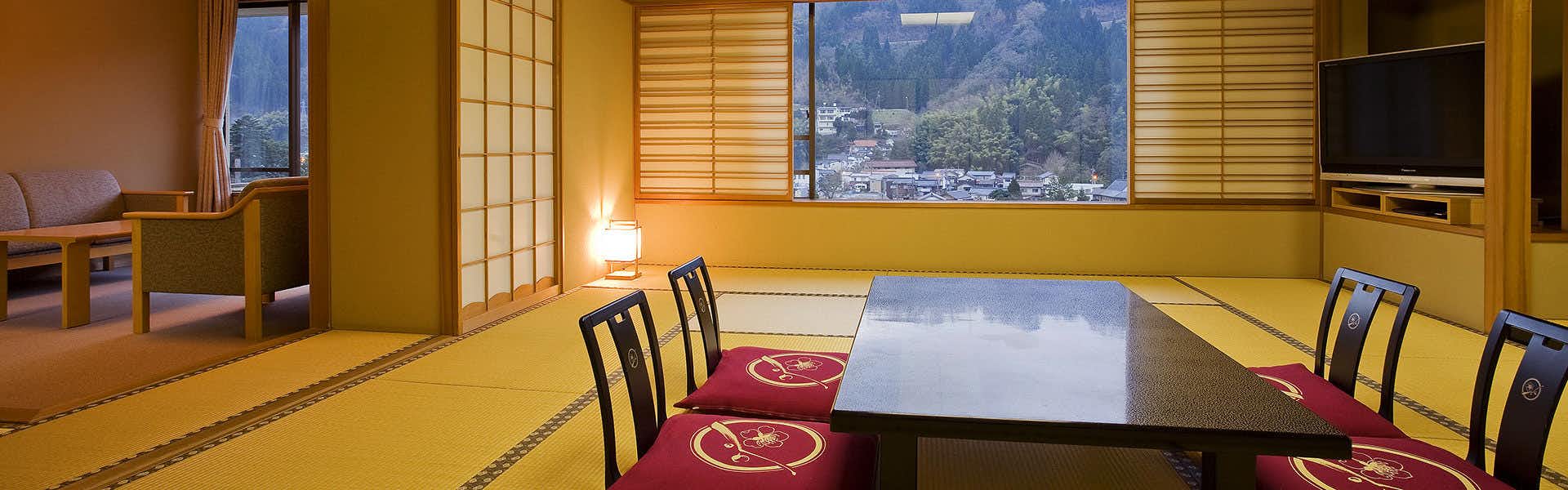 Izanro Iwasaki with a traditional tatami room beside broad mountain windows.