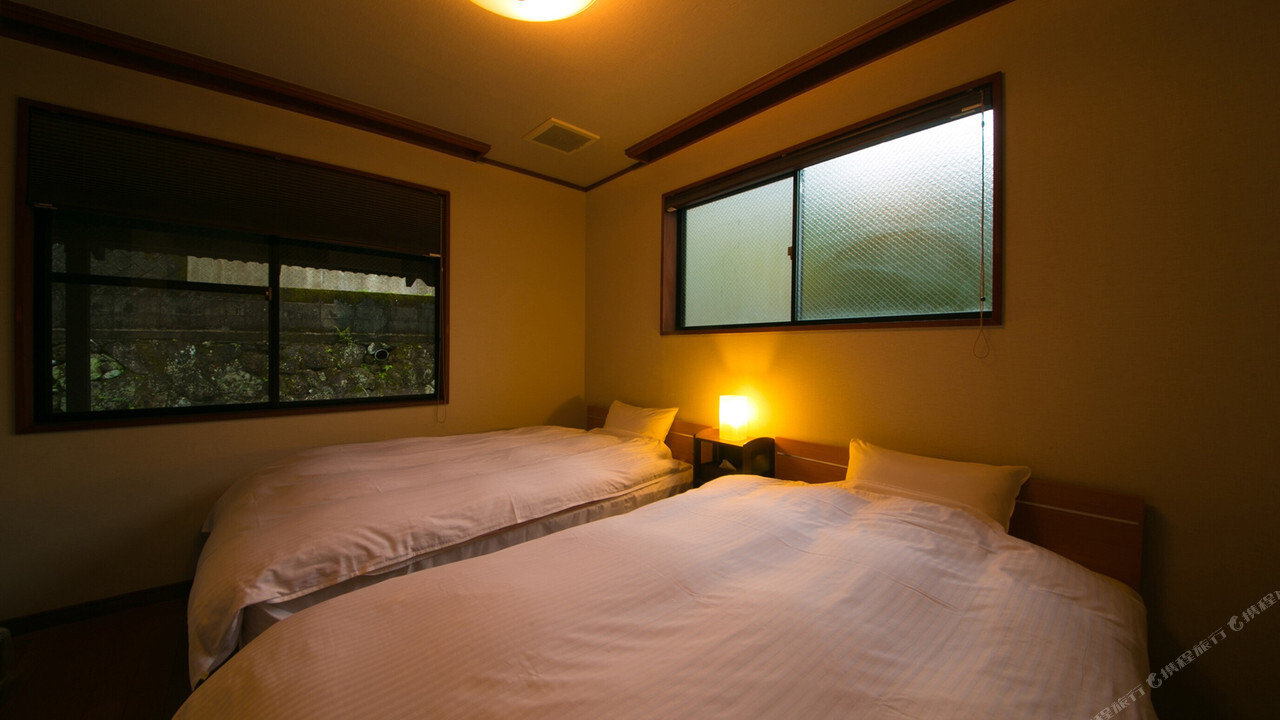 Guest room with beds and a wide window.