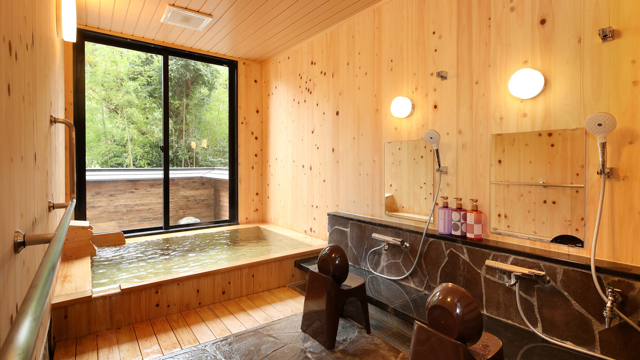 A wood-lined bath looks across a forested valley.
