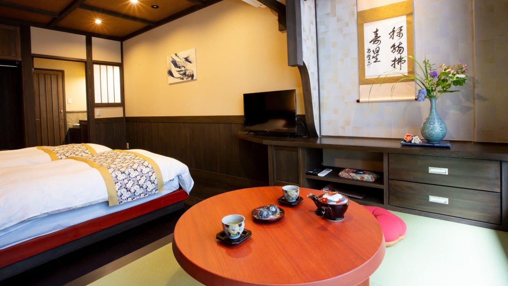 Kurokawa Onsen Ryokan Misato with a guest bedroom with patterned runner and red low table.