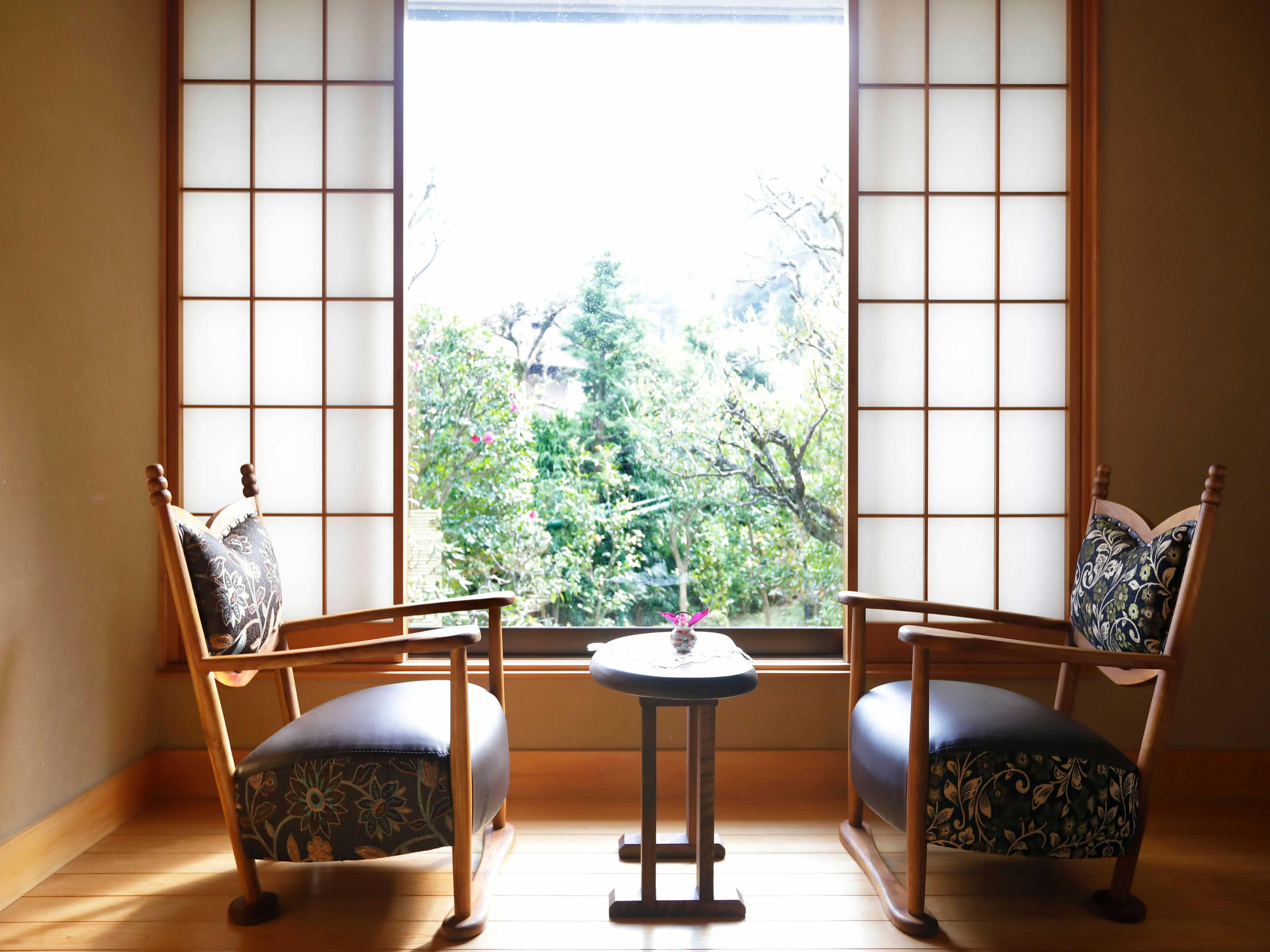 Hakone Ohiradai Onsen Sansuiso with a window seating area with patterned armchairs and garden view.