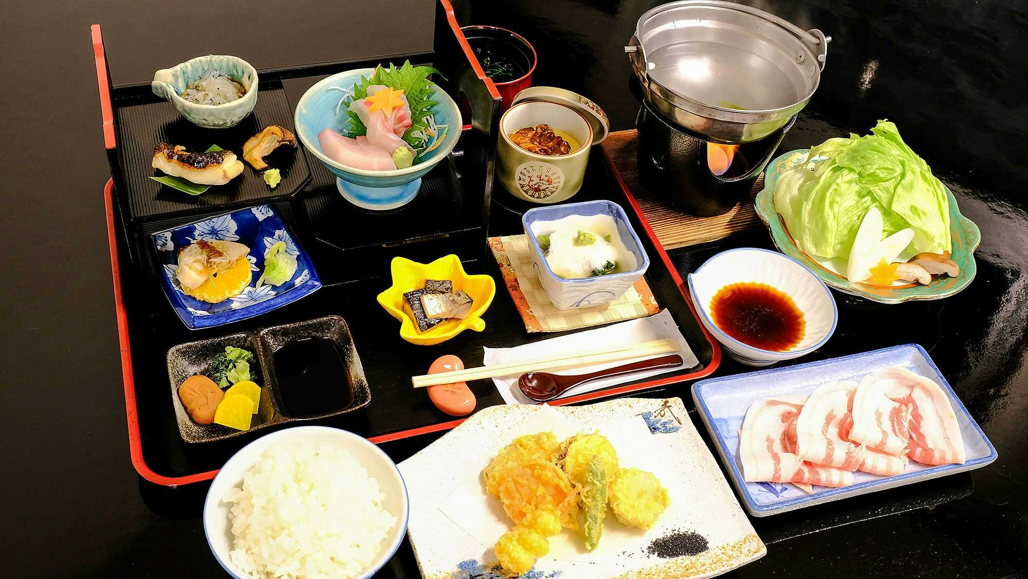Hotel Sunset Susami with a Japanese dinner arranged across black lacquered trays.