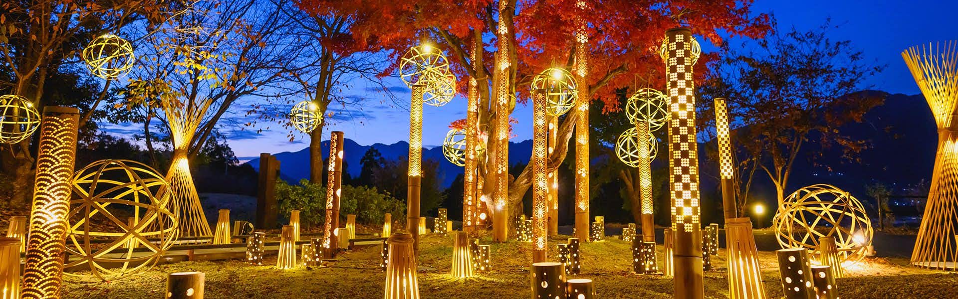 World Heritage Resort Kumano Club with illuminated art structures arranged among colorful autumn trees.