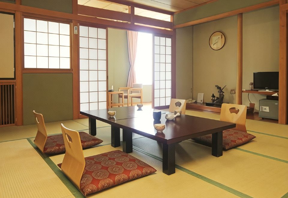 A low table and floor chairs in a traditional room with shoji windows.