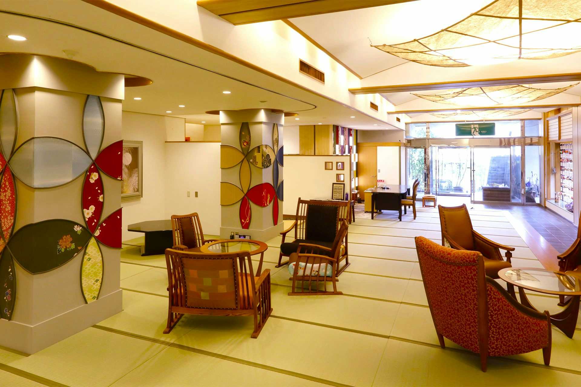 Rakuzan Yasuda: A Tatami-Floored Inn Adorned with Kimonos with a colorful lobby with kimono-pattern panels and upholstered chairs.