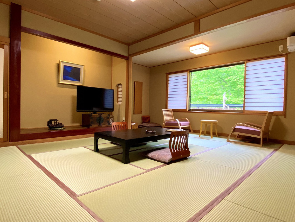 A tatami room includes a low table, television, and garden-facing windows.