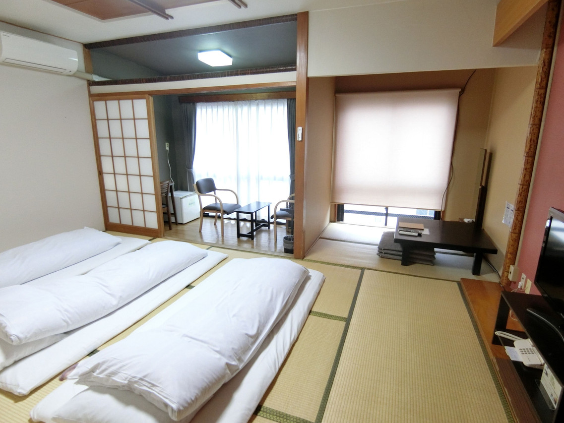 A Japanese-style room with futons and a window.