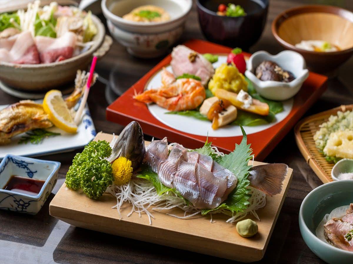 Ryokan Kinokuniya Jinpachi with a multi-course dinner arranged across red lacquered plates.