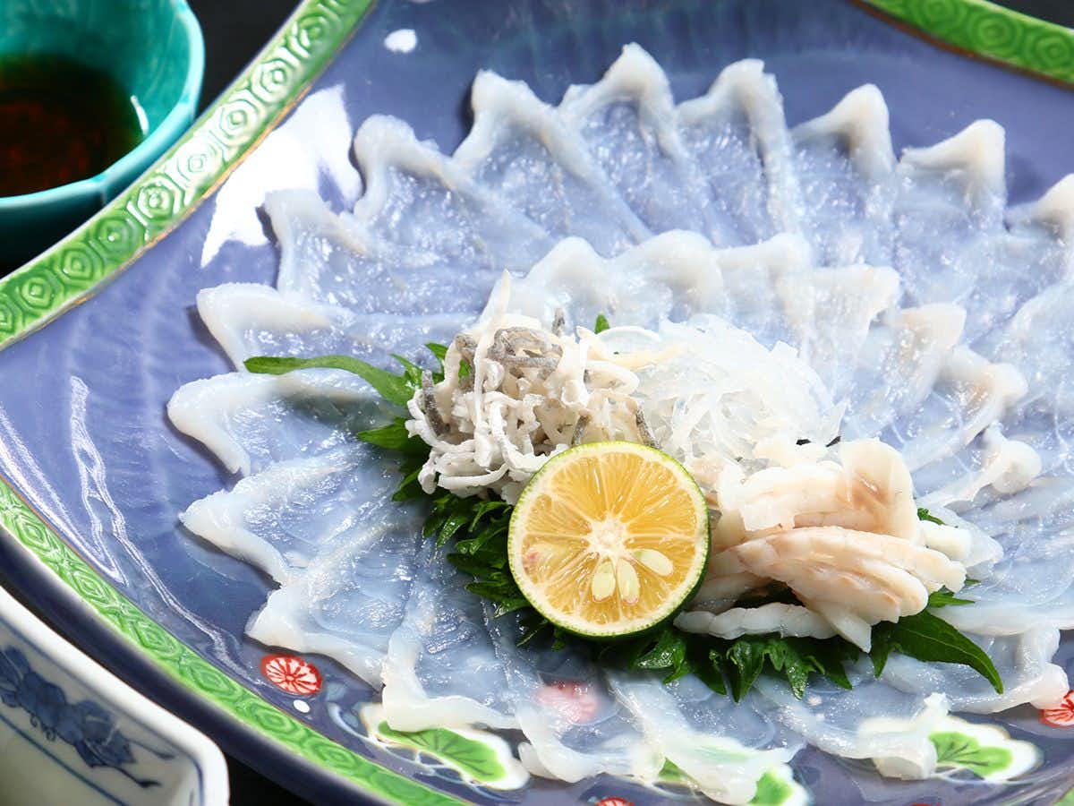 Ryokan Hisada with thinly sliced blowfish arranged in a circular pattern.