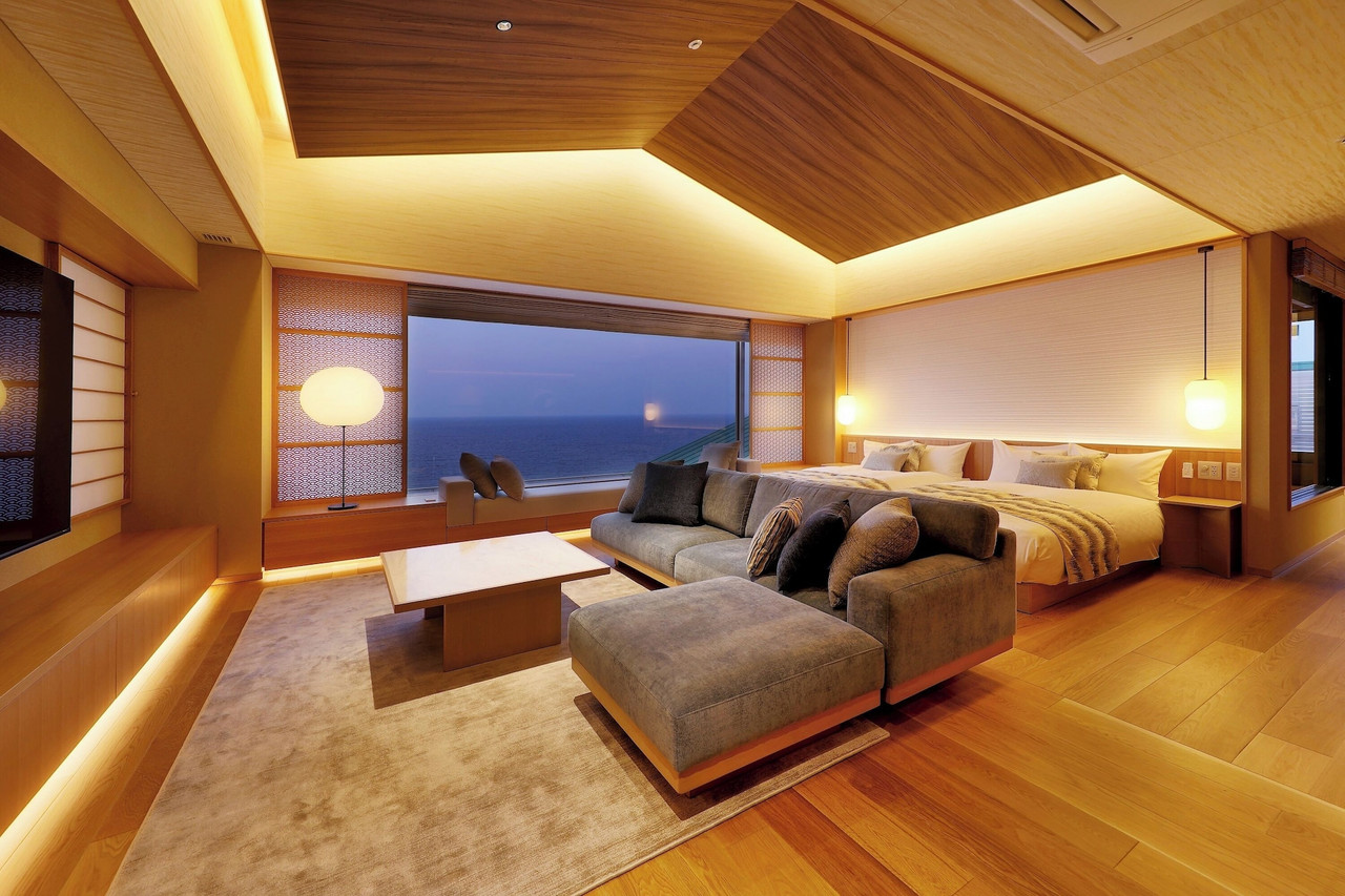 A bedroom with a sea view and seating.