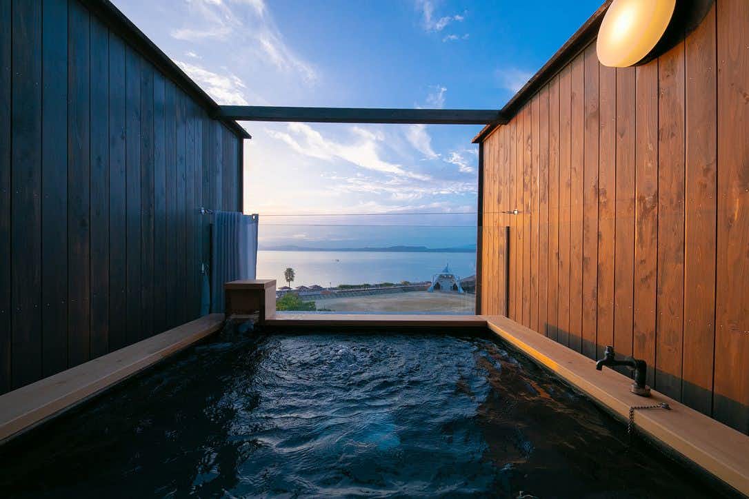Tsutaya Ryokan open-air bath framed by wooden walls with a broad sea view