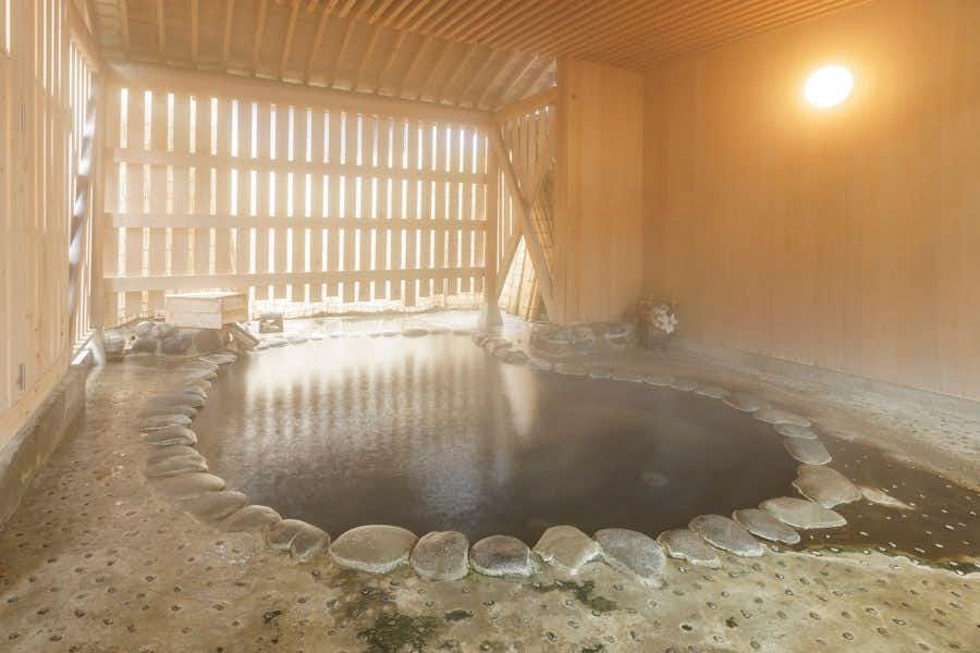 Matsudaya Ryokan with a steamy rock-lined bath beneath slatted timber windows.