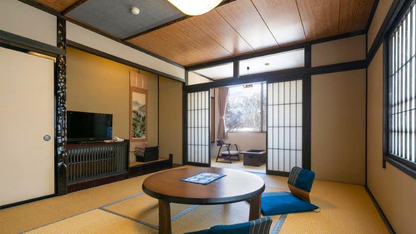Onyado Hisui with this scene, where a second tatami room combines a round table with shoji and timber framing.