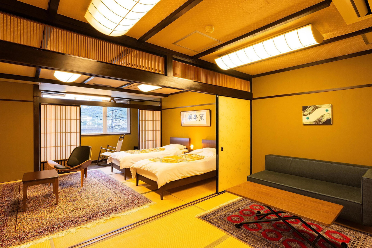 A softly lit room is arranged with beds and a low table.