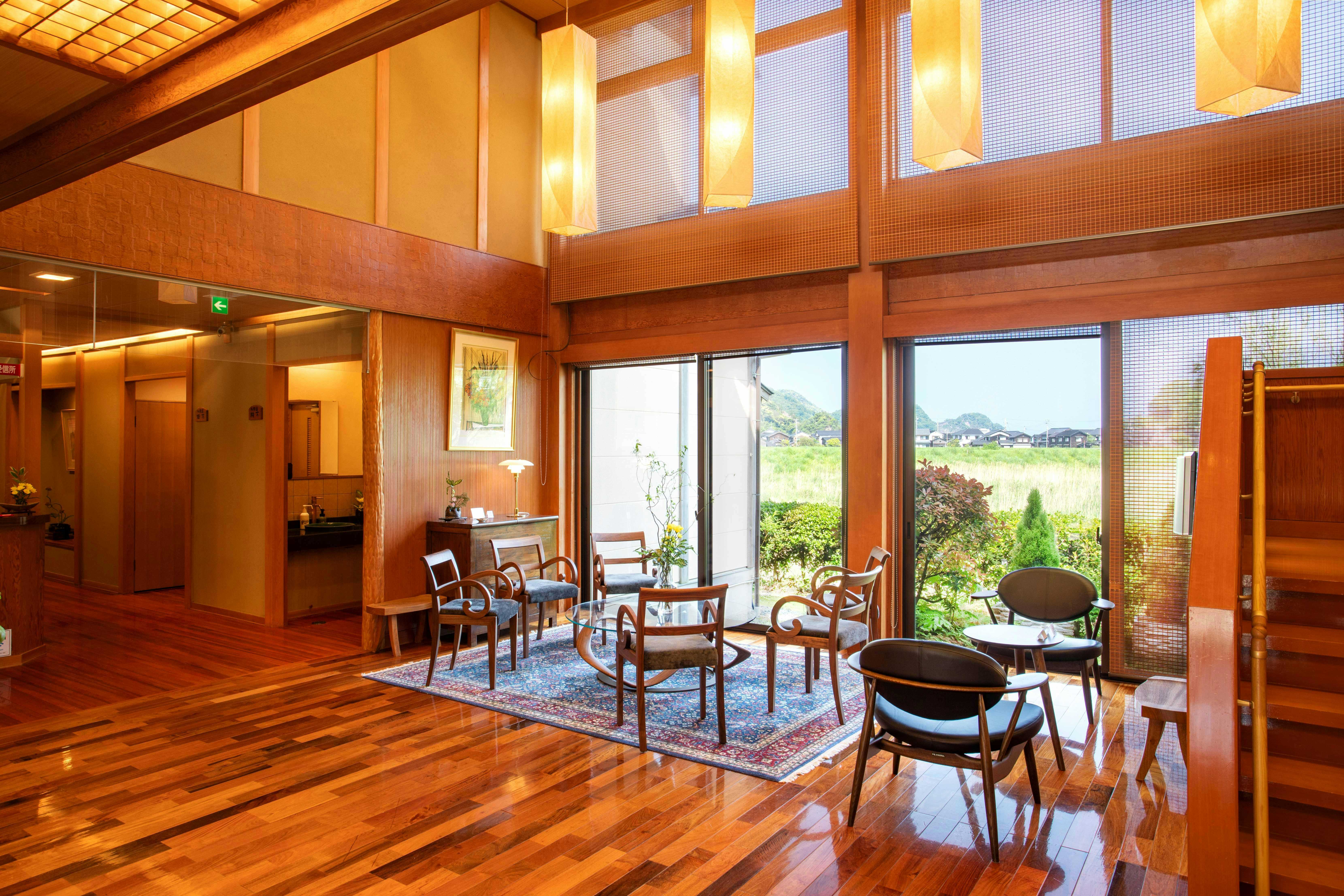 Nishitaniya Kaika with a wood-lined lounge with tall windows and garden views.